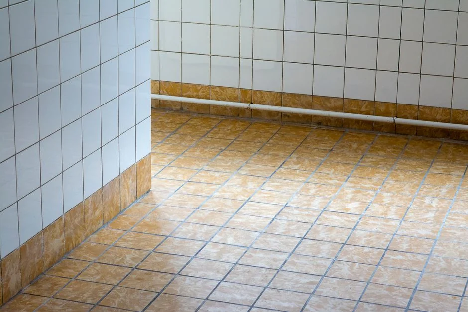 Side view of young ethnic male in uniform cleaning floor with mop while working in retro styled restaurant